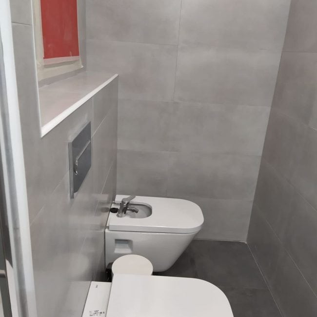 Reforma de baño moderna en Madrid con sanitarios y azulejos de alta calidad.