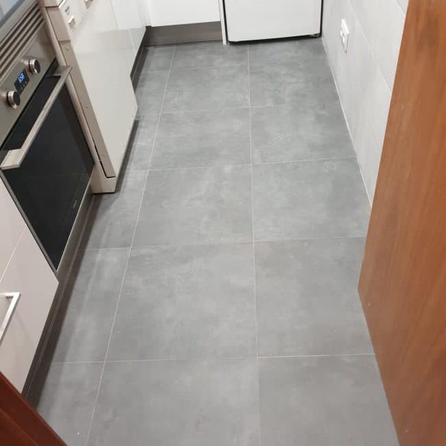 Suelo de baldosas grises en cocina moderna. Servicios de reformas integrales y reformas de cocina por Hammerman Reformas.