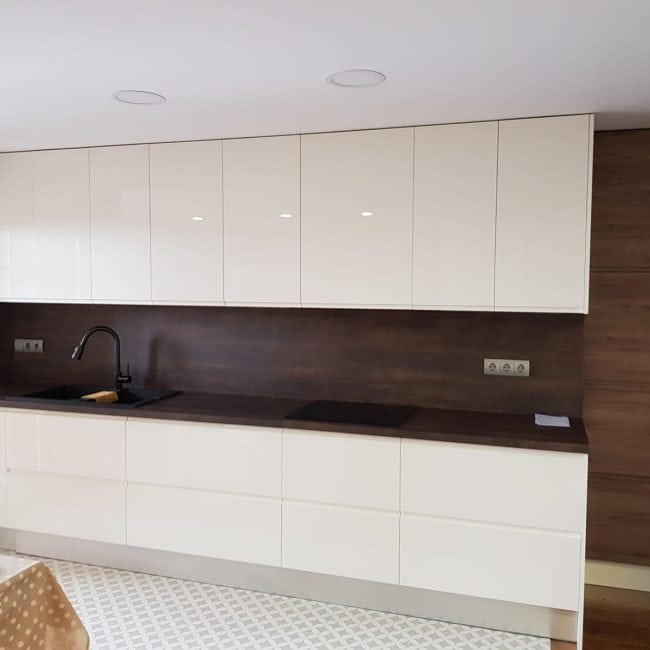 Nueva cocina moderna con muebles blancos y encimera de madera en reforma integral. Servicios de carpintería y renovación en Madrid.