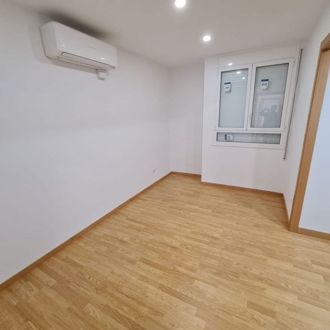 Renovación de interiores con suelos de madera y aire acondicionado en oficina moderna.