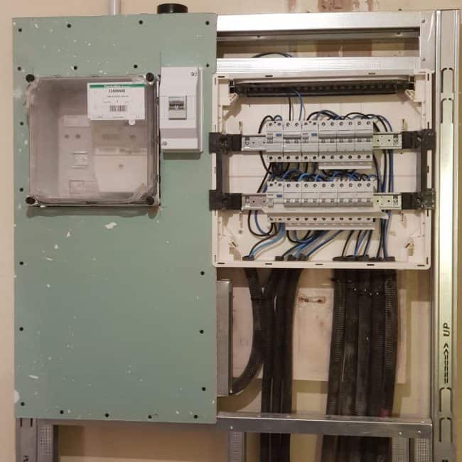 Sistema eléctrico en obra en fase de instalación con cuadro de distribution y cableado.