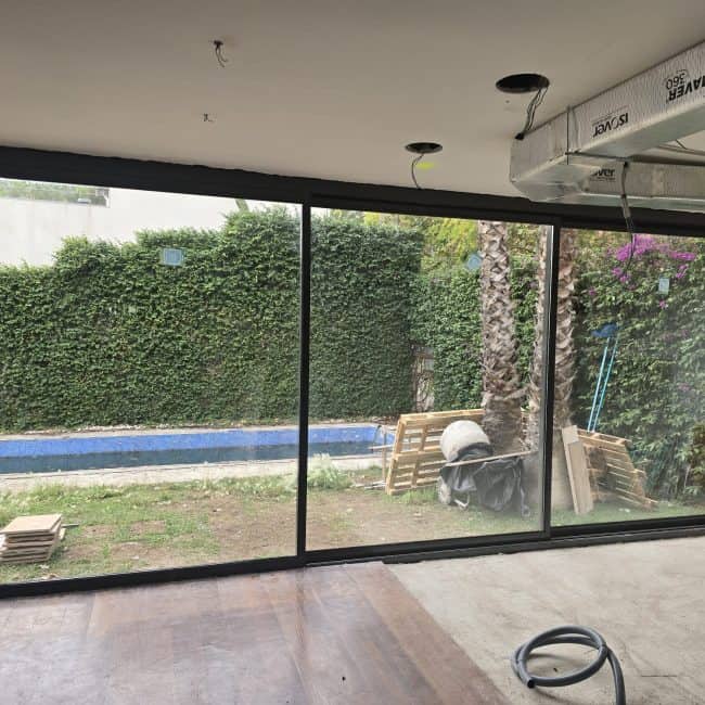 Cristalería modular para reformas de hogares con ventanas de aluminio y vista al jardín.