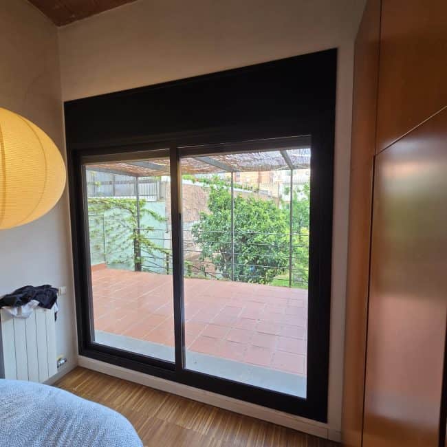 Ventana de aluminio con visión exterior a terraza, reforma integral de vivienda.