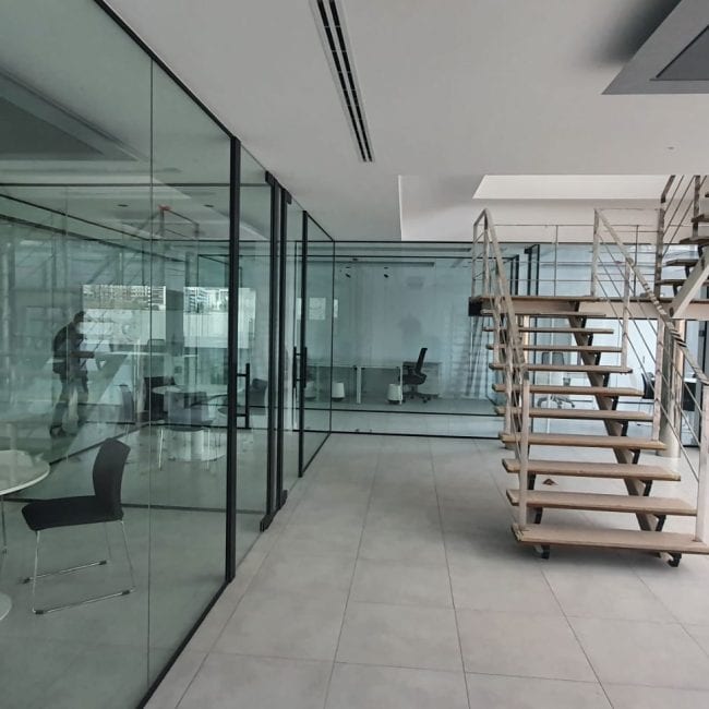Cristalería de oficina moderna con acabado en aluminio, ideal para reformas y construcciones.