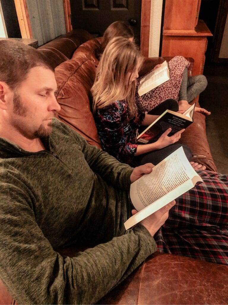 Father reading on the couch with 2 daughters