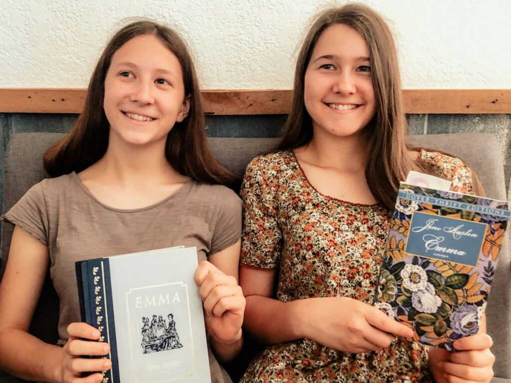 2 girls holding Emma books by Jane Austen