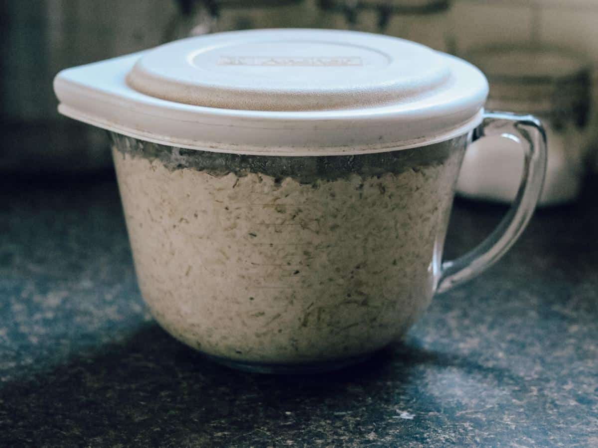 oats soaking in a glass bowl with white lid for soaked baked oatmeal