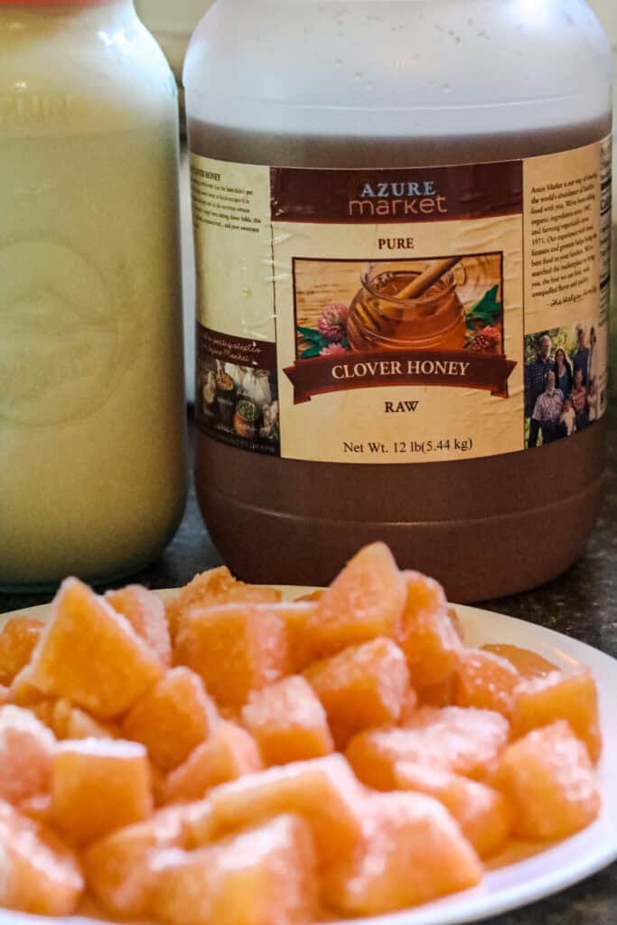 muskmelon on a plate with honey and raw milk on the counter