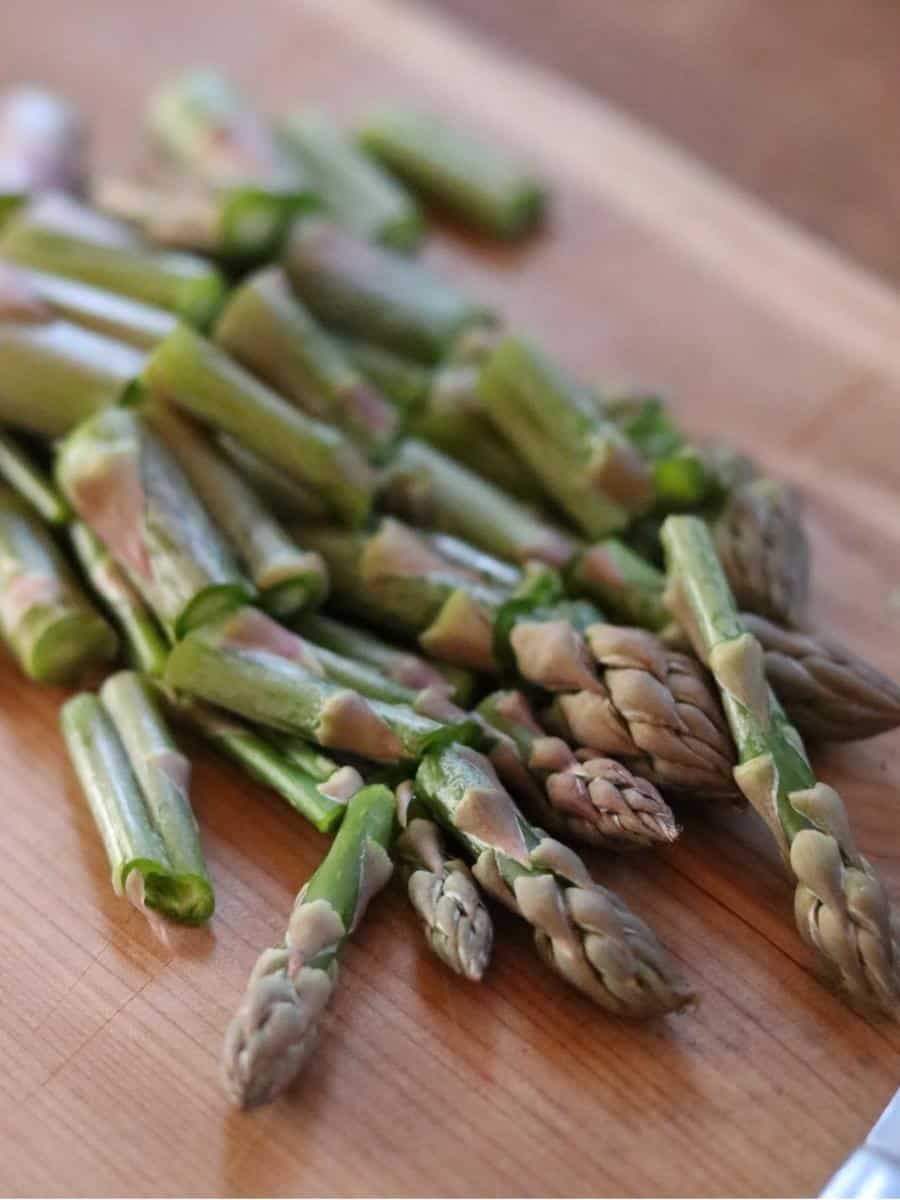 asparagus spears chopped on a wooden cutting board