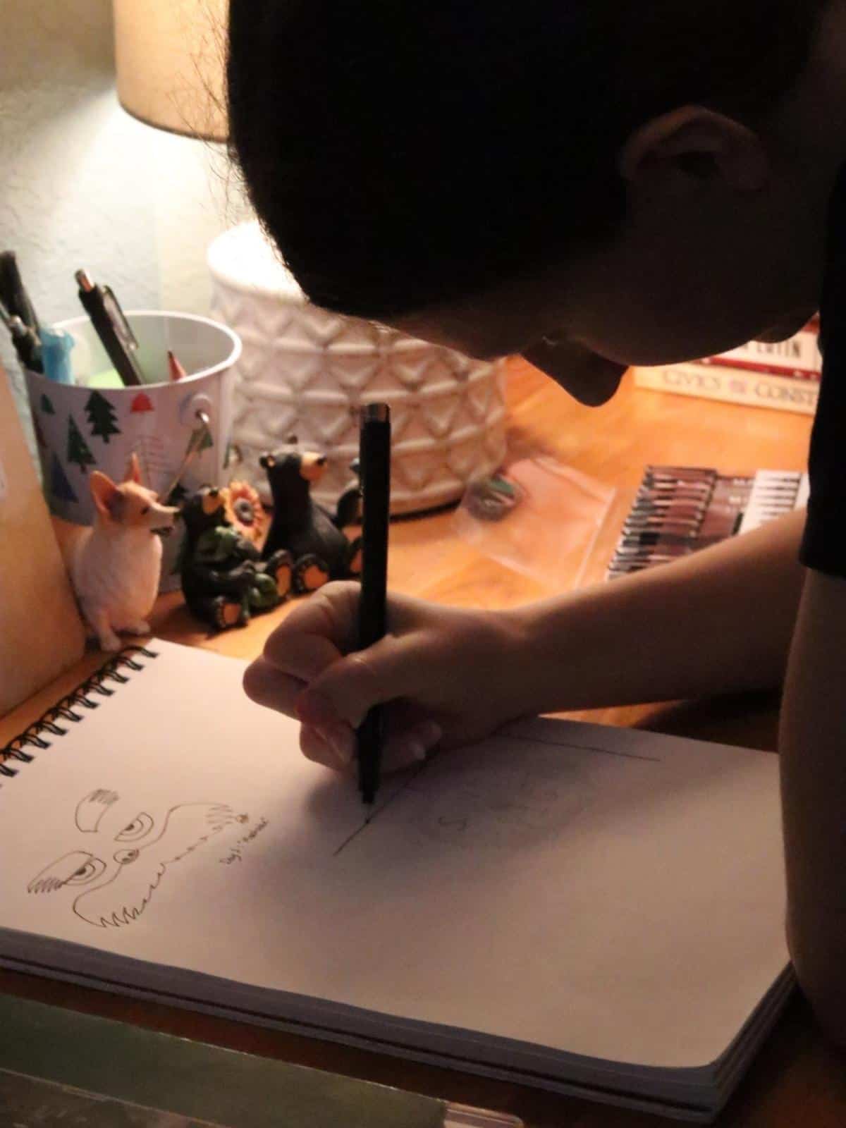 enjoying the benefits of inktober- a girl drawing in a sketchbook