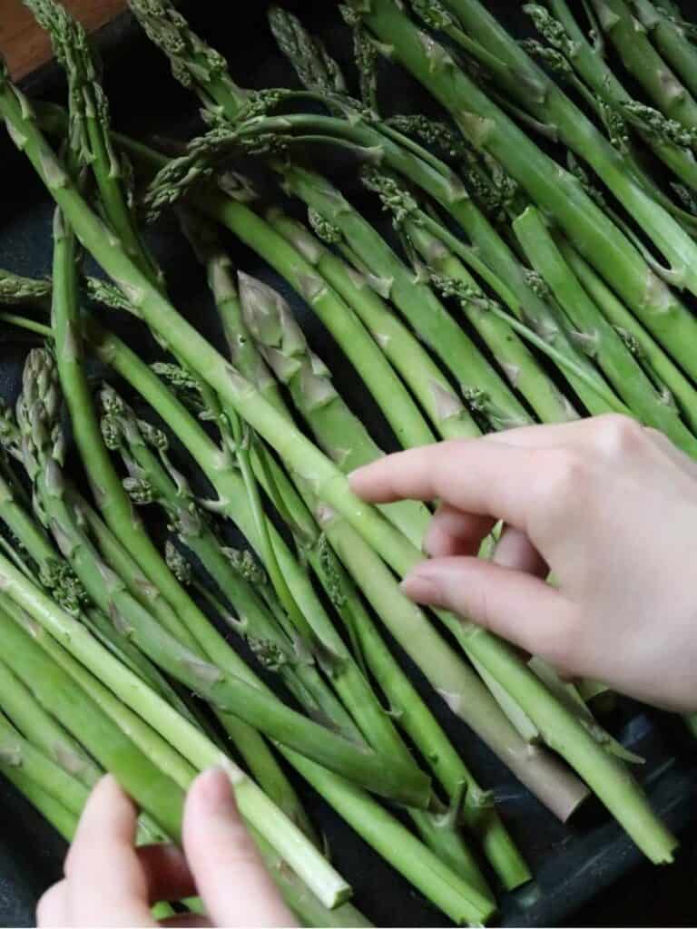 arranging asparagus stalks for a roasted asparagus recipe