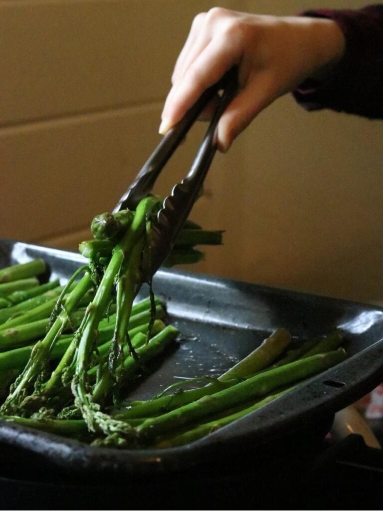 turning asparagus stalks for roasting with tongs