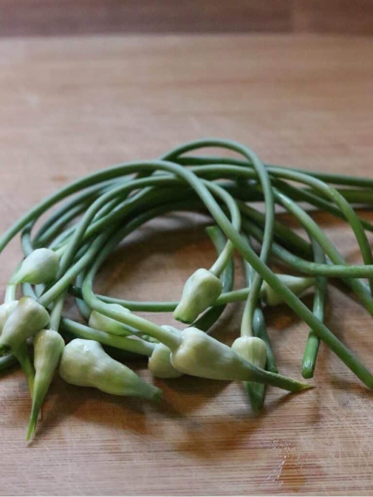 garlic scapes on a cutting board