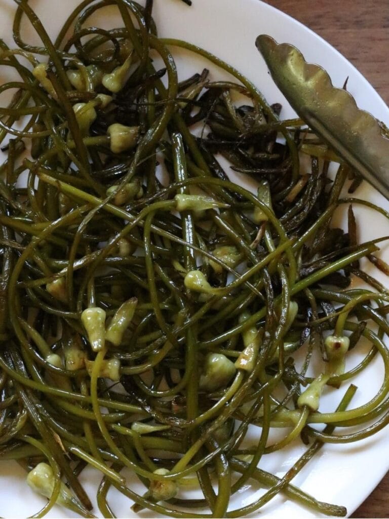 sautéed garlic scapes on a white plate