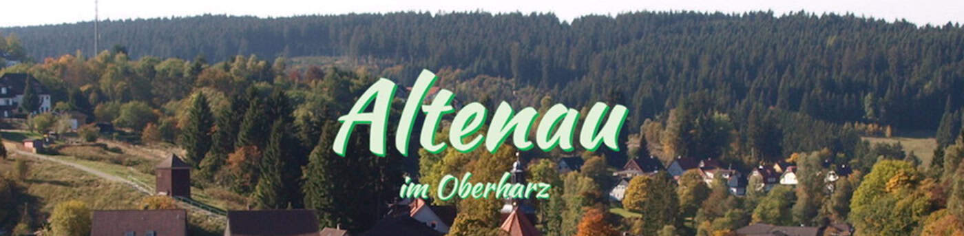 Altenau-Header_1400 Eine malerische Aussicht auf Altenau im Harz. Im Vordergrund sind Häuser zwischen Bäumen zu sehen, im Hintergrund ein üppiger Wald unter klarem Himmel. Der Text lautet „Altenau im Oberharz“.