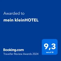 booking-award Blaue Grafik, die einen Booking.com Traveller Review Award 2024 zeigt. Unten rechts steht „Ausgezeichnet an mein kleinHOTEL mit einer Bewertung von 9,3 von 10“.