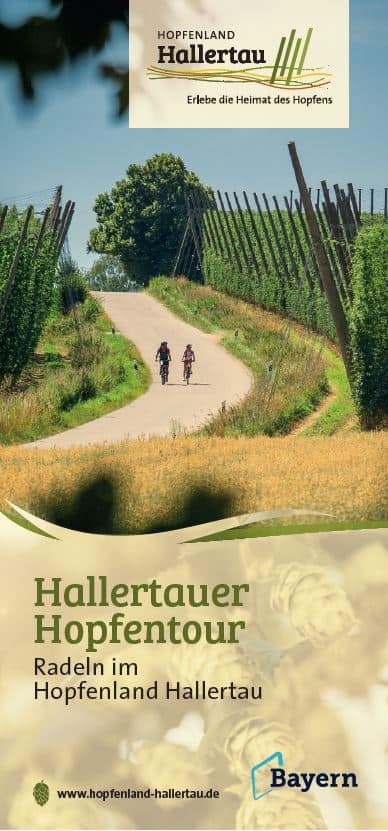 Cover - hallertauer hopfentour Zwei Radfahrer fahren unter klarem Himmel einen Weg entlang, der von üppig grünen Hopfenfeldern gesäumt ist. Der Text wirbt für die Hallertauer Hopfentour und fördert das Radfahren im Hopfenland Hallertau mit Logos für Hallertau und Bayern.