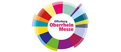 Eine farbenfrohe, segmentierte Kreisgrafik mit dem Schriftzug Offenburg Oberrhein Messe in der Mitte, die die Offenburger Oberrhein Messe darstellt. Die Segmente sind in verschiedenen leuchtenden Farben gehalten.
