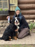 K-9 handler with a Bernese Mountain Dog, showing off a certificate of achievement, highlighting successful training and certification in dog handler programs at High Plains K-9 Connections.