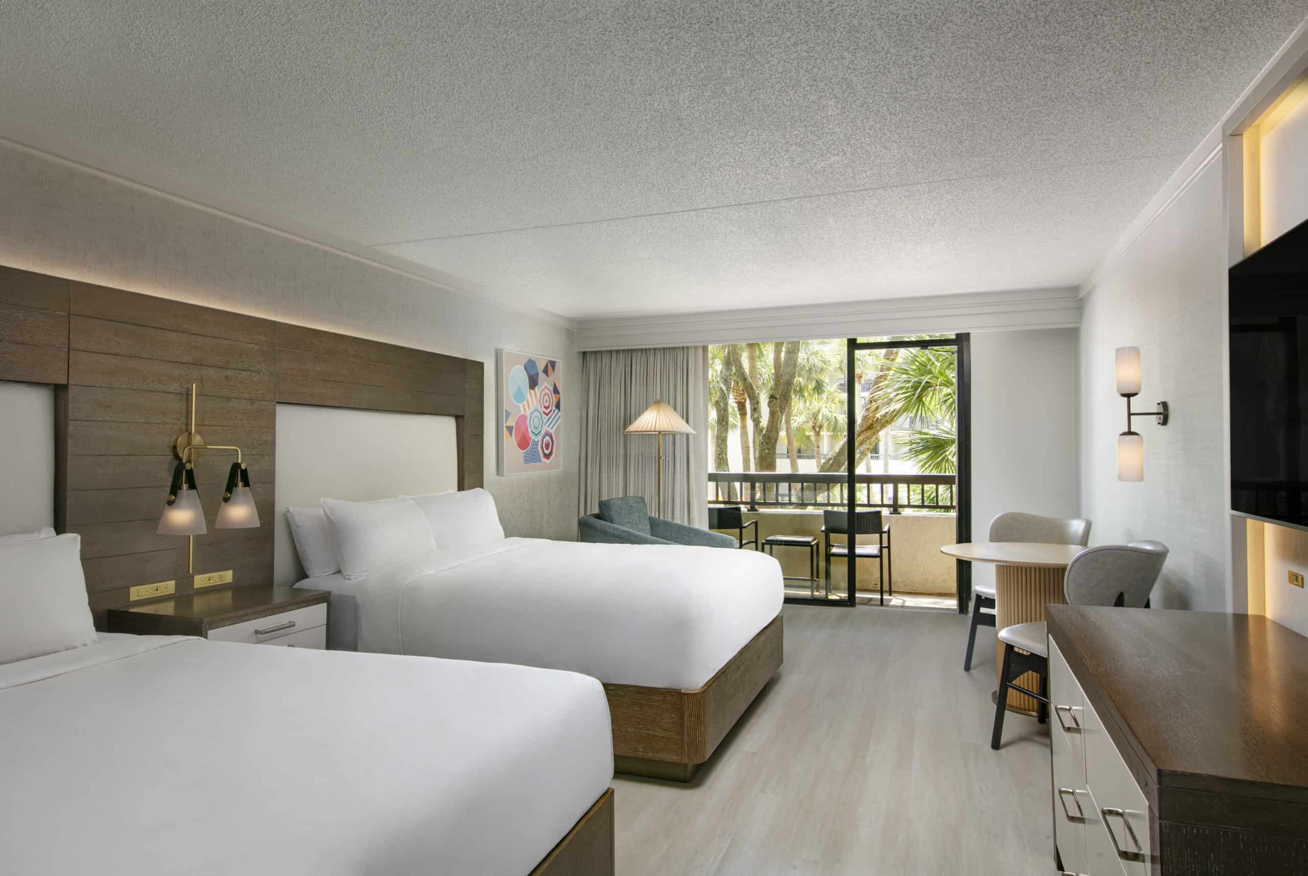 Spacious hotel room with balcony and seating.
