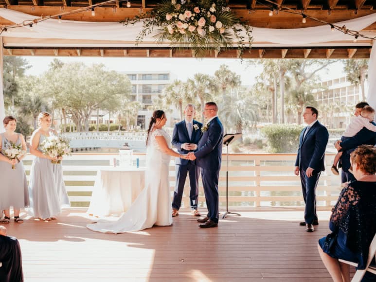 Couple exchanging vows during outdoor wedding ceremony.