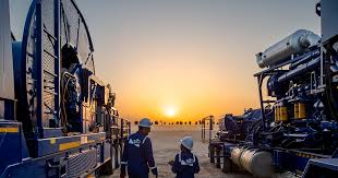 Engineers inspecting industrial equipment at sunset site.