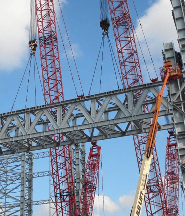 Construction crane and steel framework under blue sky.