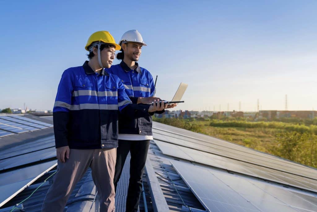 specialist technician professional engineer with laptop tablet maintenance checking installing solar roof panel factory rooftop sunlight engineers team survey check solar panel roof (1)