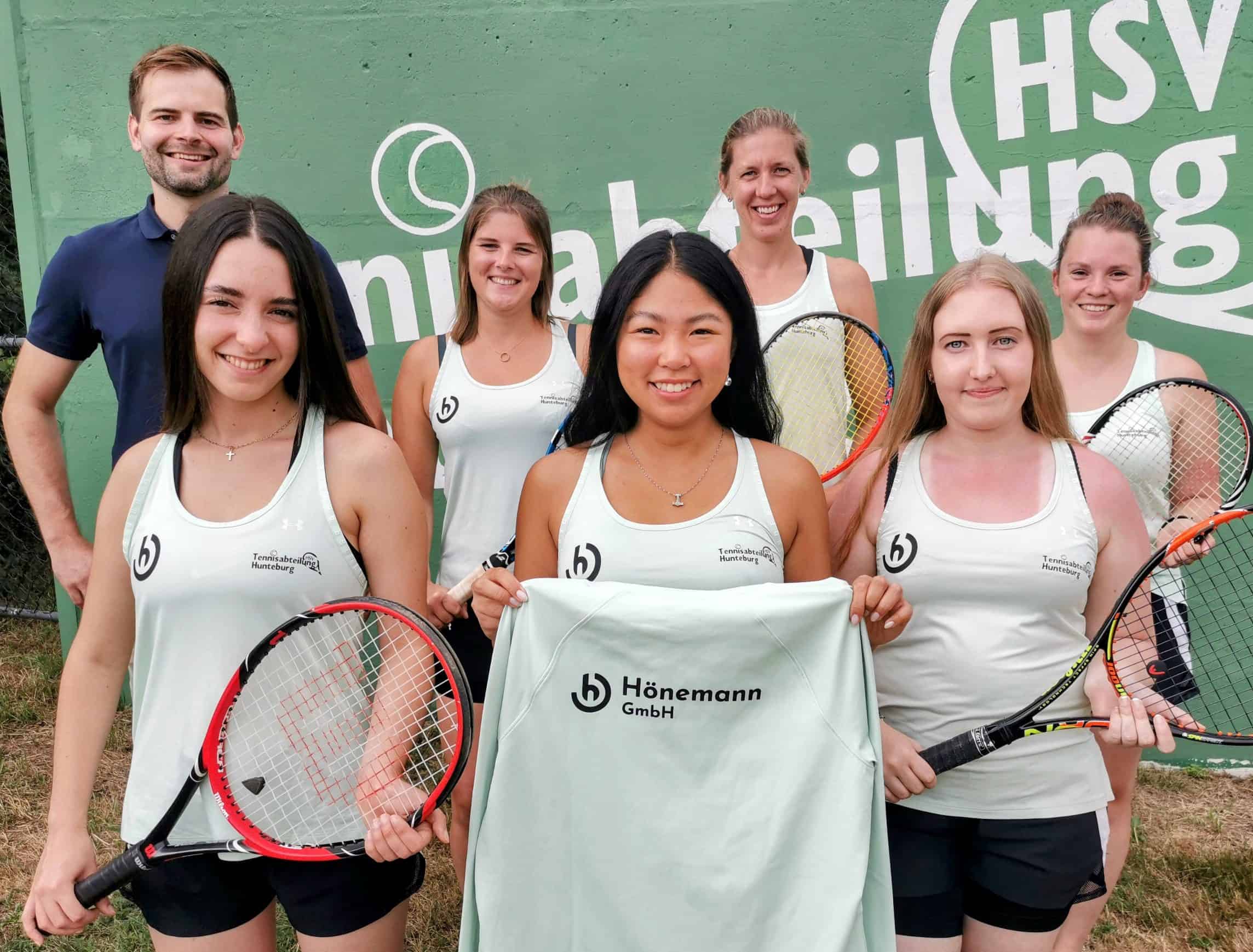 Frauen-Tennisteam des Hunteburger SV mit Sponsor Hönemann auf dem Tennisplatz.