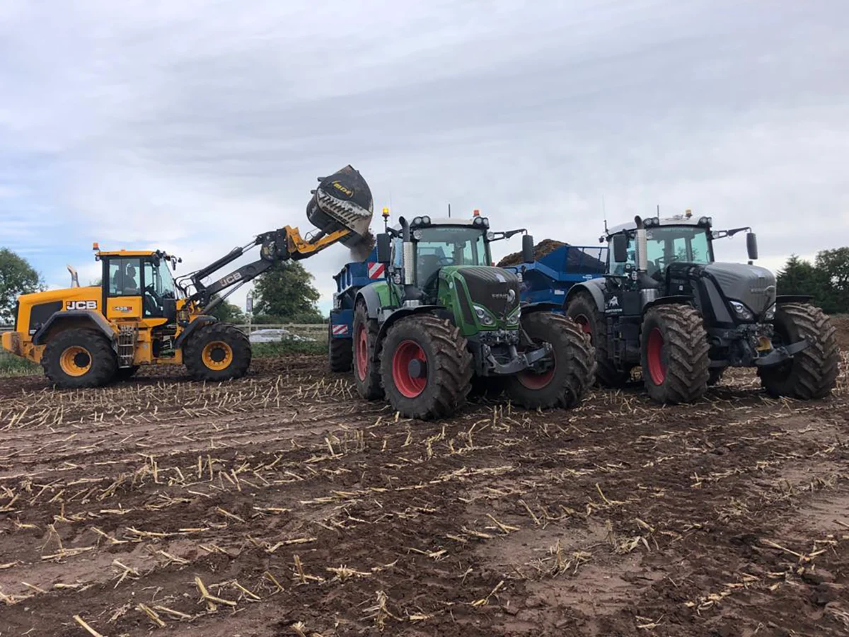 Loader and Spreaders Tractors working in field with loader equipment.