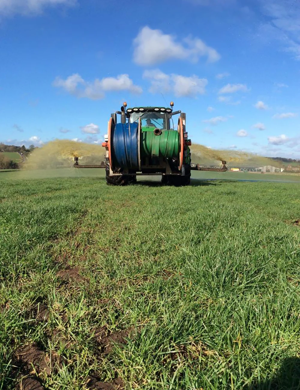 PHOTO-2021-12-13-10-34-31 Tractor spraying fertilizer on green grass field