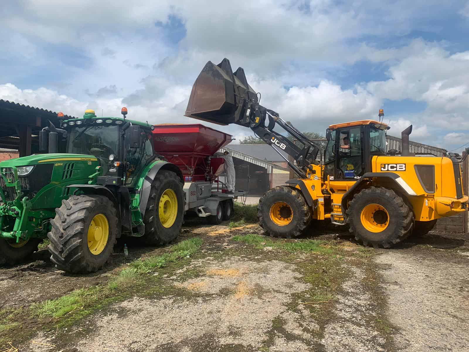 138e4552-4194-46c1-8a72-957414e67503 Tractor and backhoe loader work on a farm.