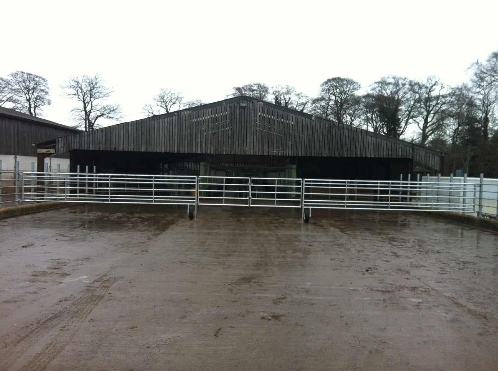 Gates 6 Barn with metal gates on cloudy day.