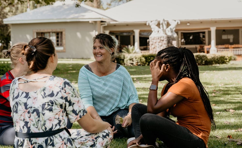 Hope Again Wellness Center, diverse group therapy session outdoors, mental health support, healing, community, women’s mental health, wellness, recovery, holistic therapy, mental health services, counseling.
