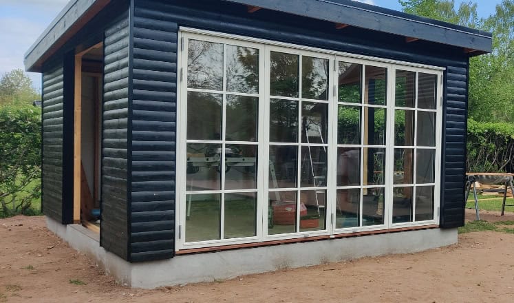 Tilbygning i træ med flotte og store vinduer