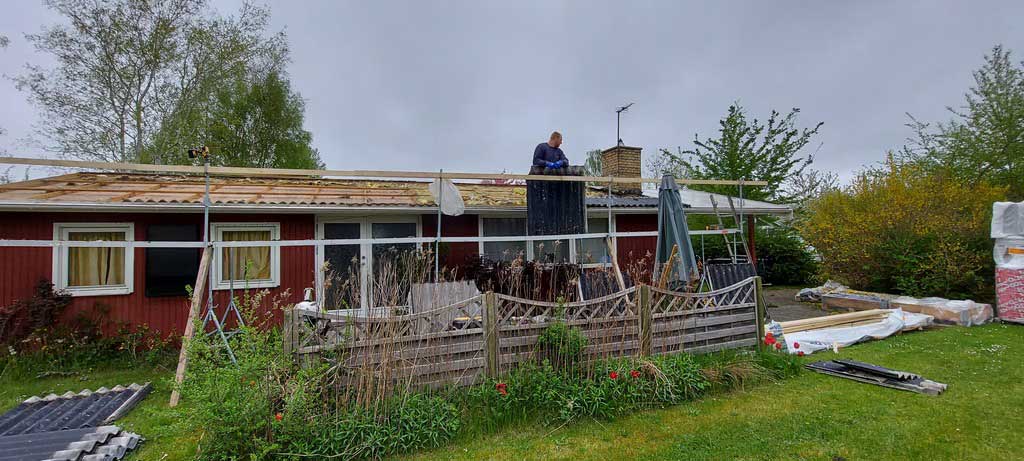 Tagrenovering under opbygning på rødt træhus