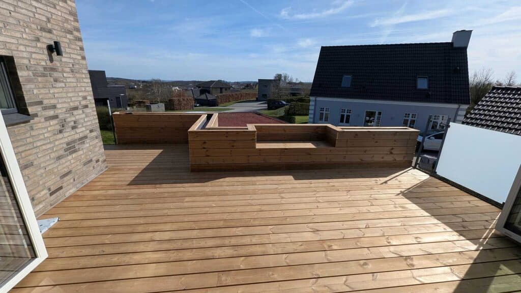 Stor træterrasse med en indbygget siddebænk af brædder.