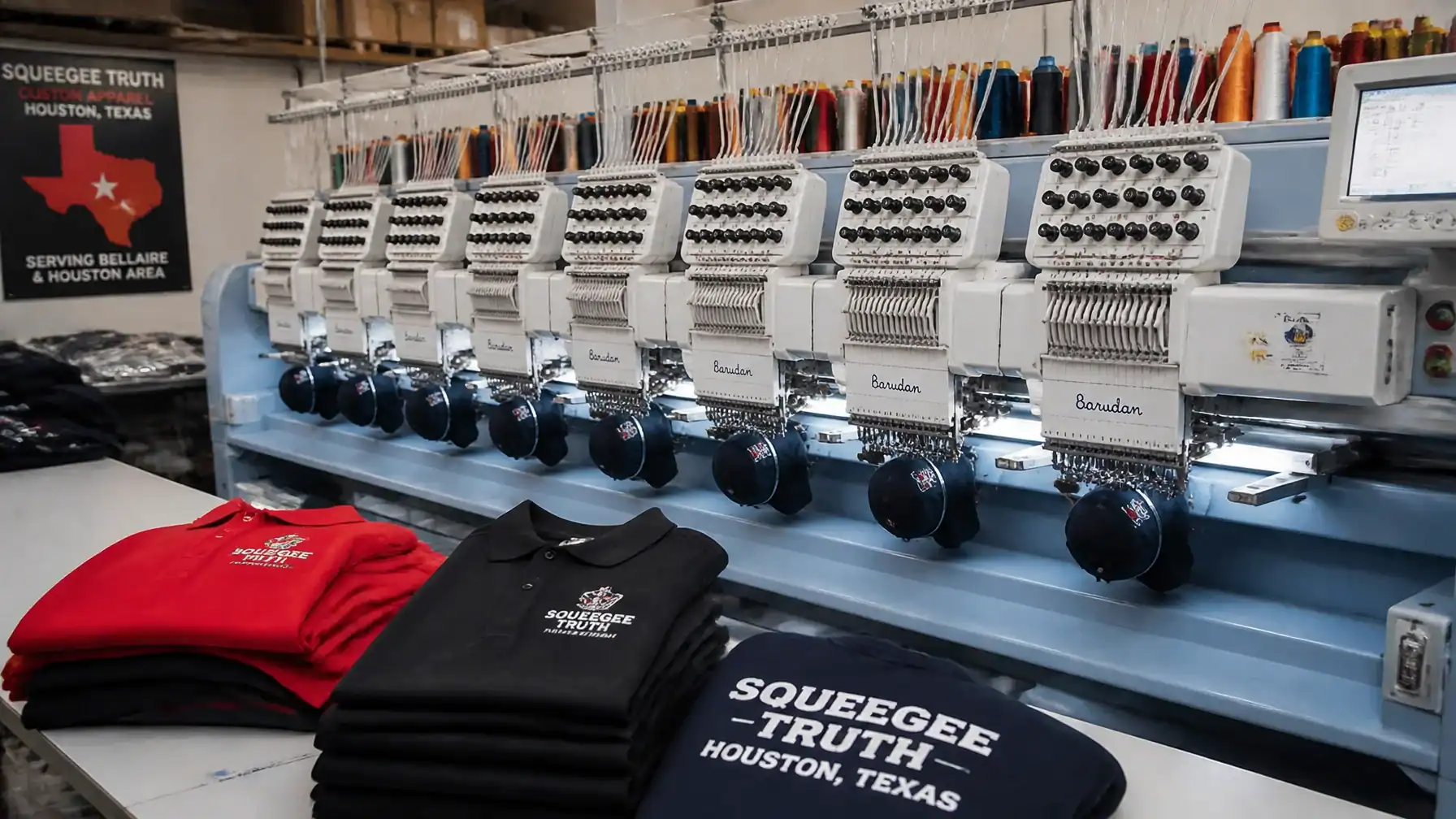 Industrial Barudan embroidery machines and shop materials in active custom apparel production for Bellaire orders