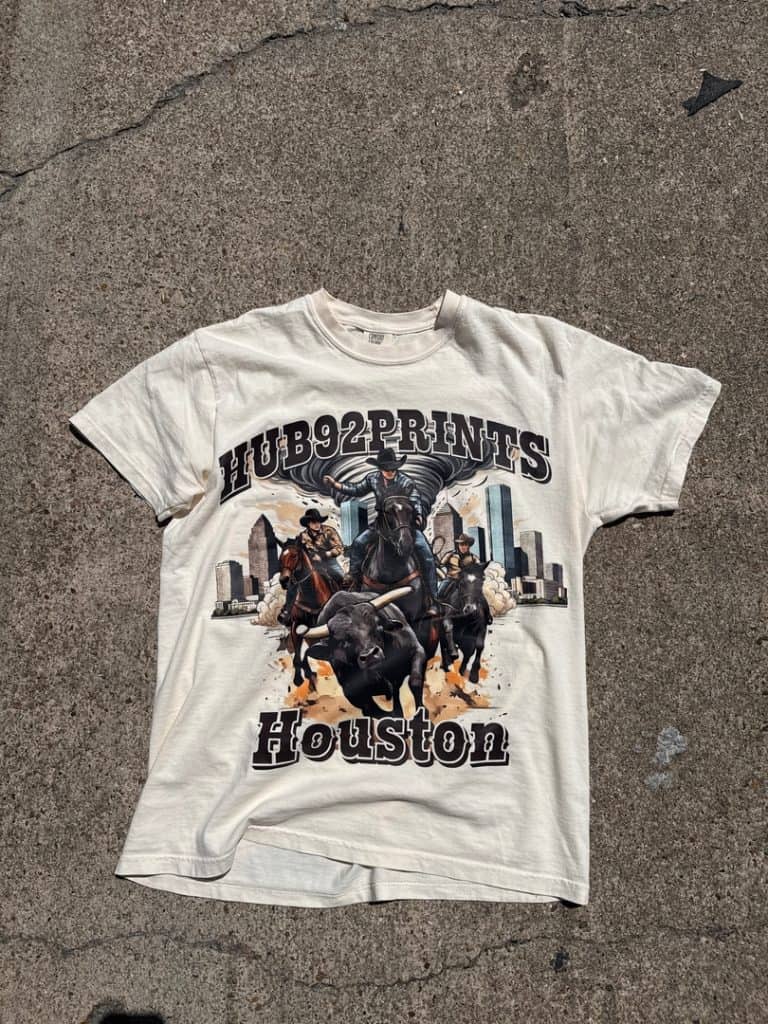 Custom T-shirt featuring a cowboy and rodeo theme with horses and a bull, set against a city skyline background, showcasing the text "Hub92prints" and "Houston.