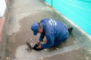 Técnico instalando o revisando medidor de agua en la vía pública en Neiva, durante la polémica por cambio obligatorio de medidores de agua potable.