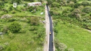 Imagen aérea de la pavimentación de la vía La Piedra – Gallego en La Plata, mostrando el avance de la obra y el entorno natural que rodea la carretera.