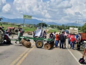 Manifestantes bloquean la carretera en Huila durante el paro indefinido del sector arrocero, afectando el tránsito y la economía local en medio de las protestas.
