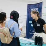 Una representante de Huila TV conversa con dos víctimas del conflicto armado en un evento de indemnización económica en Huila.