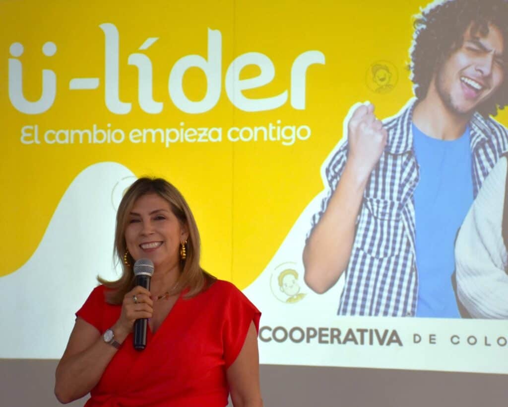 1. Mujer hablando durante evento de Huila TV con fondo amarillo y mensaje de liderazgo y cambio social.