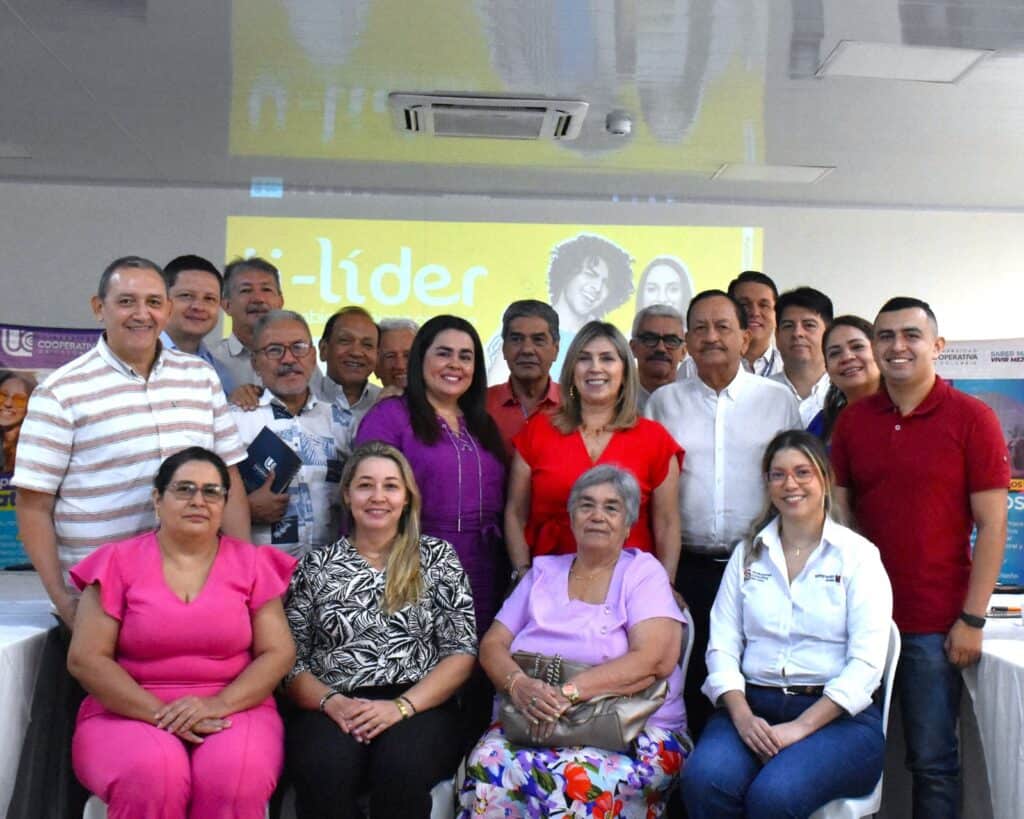 1. Grupo de personas en evento político en Huila, Colombia, promocionando liderazgo y desarrollo regional con televisión Huila Tv de fondo.