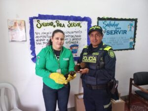 1. Policía y voluntaria sosteniendo aves en un centro de apoyo, fomentando la conservación y protección de fauna silvestre en Huila, Colombia.