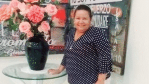 1. Mujer sonriente en Huila Tv con arreglo de flores en mural de fondo, destacando la cultura y medios de comunicación en el departamento de Huila.