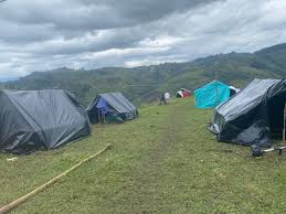 Diversas carpas en un campamento en Huila, Colombia, con paisaje montañoso y vegetación verde, ideal para actividades al aire libre y turismo ecológico en Huila TV.