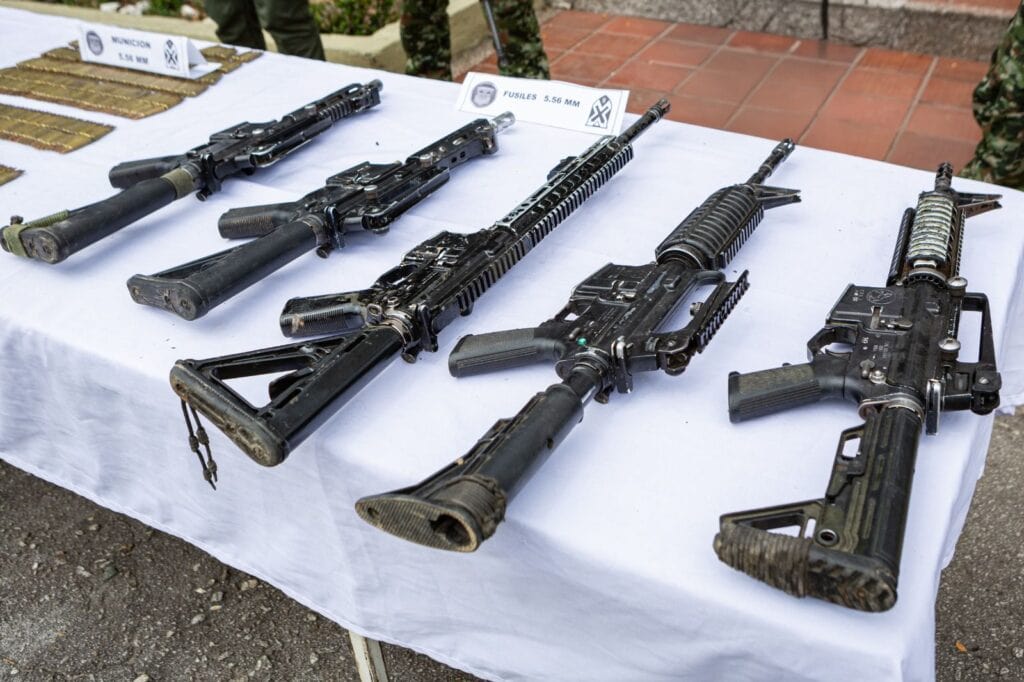 Armas de fuego y municiones exhibidas en una mesa durante una operación policial en Huila TV, destacando la incautación de armas en el departamento de Huila, Colombia.