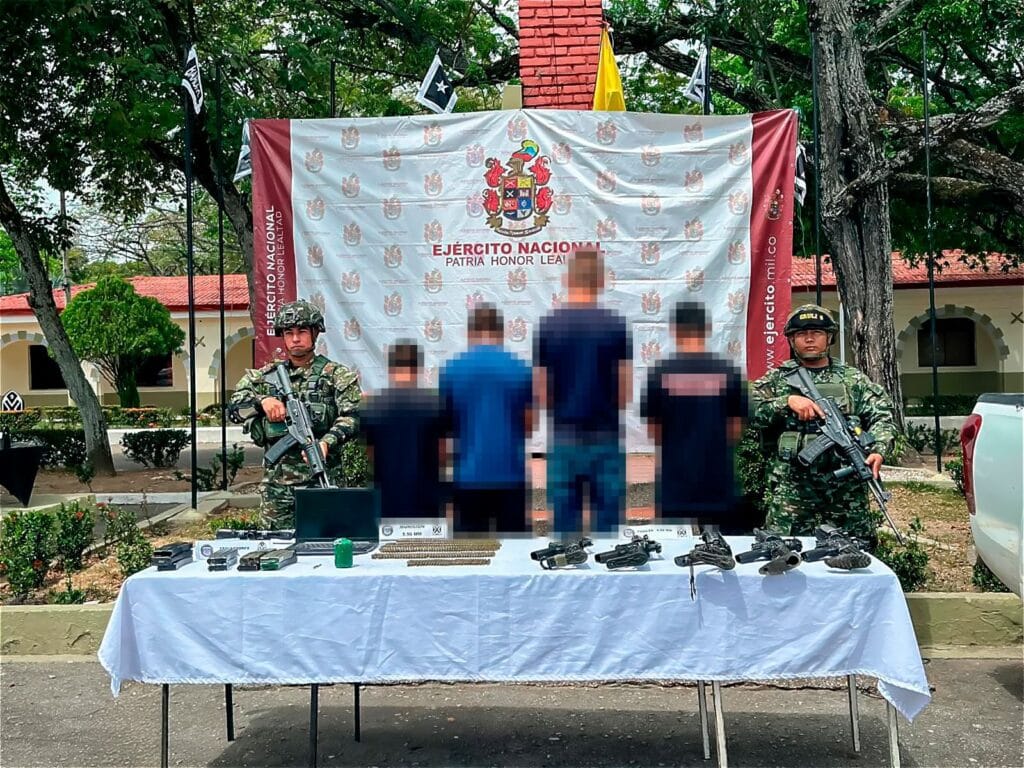 Armados y oficiales militares en operativo del Ejército Nacional en Huila, Colombia, exhibiendo armas y objetos ilícitos en una vía pública, en un escenario de control y seguridad ciudadana.